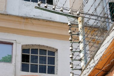 Windows hapis hücreleri bir çit dikenli tellerle yüksek gerilim altında arkasında yakın çekim