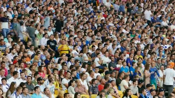 Kiew, Ukraine, Juli 2017: Eine große Gruppe von Menschen sitzt während eines Spiels auf der Tribüne eines Sportstadions — Stockvideo