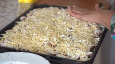 Bir kadın hamur pizza yemek pişirmek için malzemeler koyar. Eller yakın çekim
