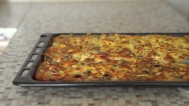 Kadın bitmiş pizza parçalar halinde keser ve Tabaklarda yerleştirir. Eller yakın çekim