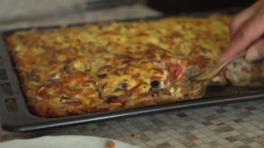 Kadın bitmiş pizza parçalar halinde keser ve Tabaklarda yerleştirir. Eller yakın çekim