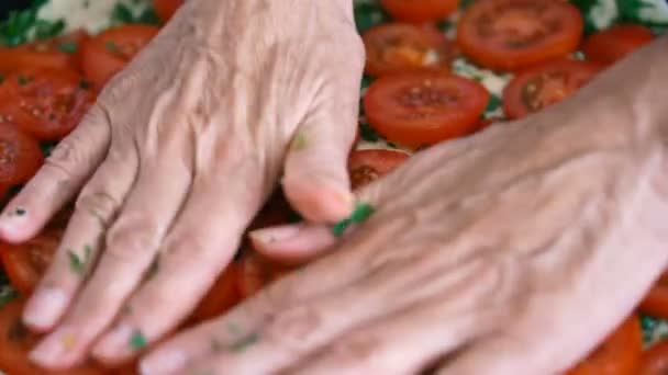Una mujer pone tomates en una masa para pizza. Las manos de cerca — Vídeos de Stock