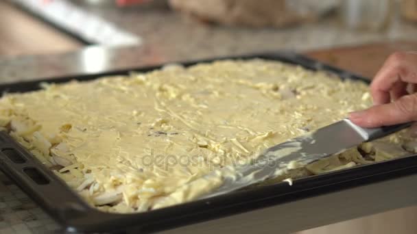 Жінка кладе інгредієнти на тісто для приготування піци. Руки крупним планом — стокове відео