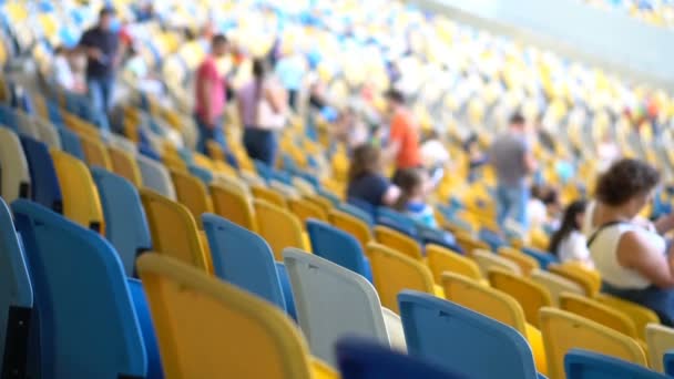 Filas de asientos en el estadio. Los espectadores van a ver el evento — Vídeo de stock