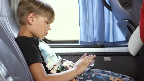 El niño viaja con un smartphone en el autobús. Disfruta de la victoria en el juego de ordenador. Primer plano — Vídeos de Stock