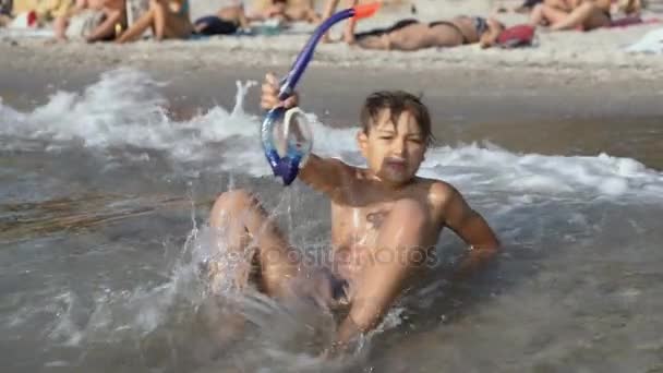 Мальчик в маске и трубке для подводного плавания купается в море — стоковое видео