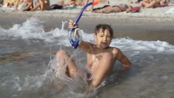 Um menino com uma máscara e um tubo de mergulho banha-se no mar — Vídeo de Stock