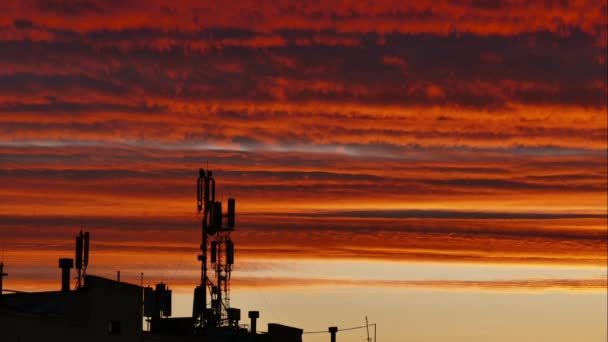 Silhueta de antenas de comunicação móvel em um pôr-do-sol cor de laranja. Calendários — Vídeo de Stock