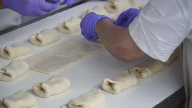 Kadınlar rulo üzerinde bir fırın Konveyör bant üzerinde olun. Eller yakın çekim