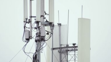 Bir bulutlu gökyüzü arka planda telekomünikasyon anten. Kuşlar anten asılı. Yakın çekim