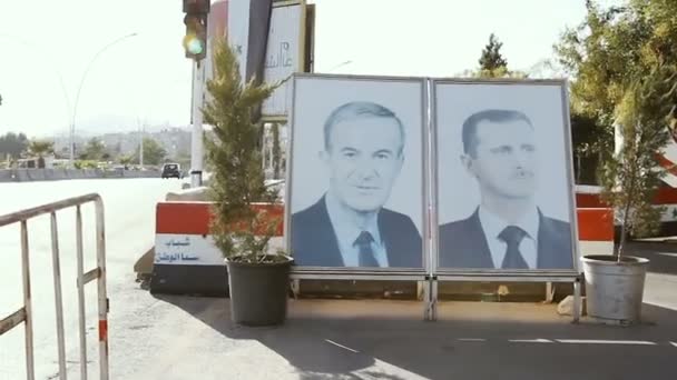 Sýrie, Damašek, září 2013: Portréty Bašára a Háfiz Asad jsou instalovány u cesty v Damašku — Stock video