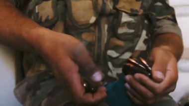 Damascus, Suriye, Eylül 2013: Bir asker ile bir makineli tüfek mermi yükler. Eller yakın çekim