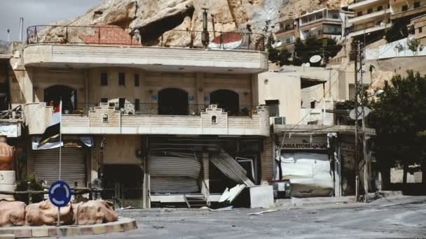 Maalula，叙利亚，9 月 18 日： Maalula，叙利亚，2013 年 9 月： 叙利亚国旗附近的争斗在 Maalula 中受损的建筑 — 图库视频影像