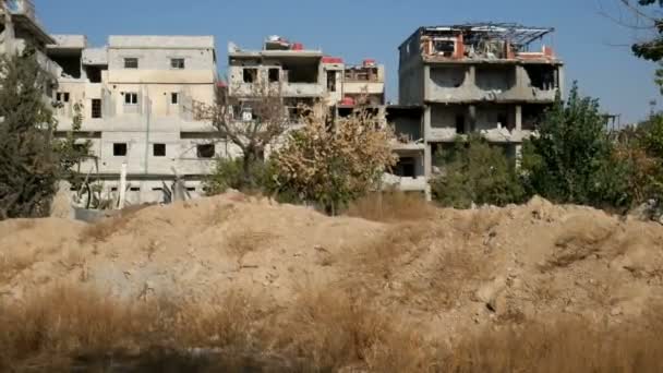 Damascus, Syrië, September 2013: Verwoeste huizen in de buurt van de weg die Damascus verbindt met de luchthaven. Het gebouw verwoest in de gevechten tussen de rebellen van de Syrische nationale leger — Stockvideo