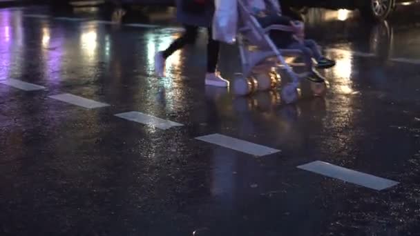 A mozgalom a gyalogosok zebra. Város utcája. Őszi esős estén. Közeli kép: lábak — Stock videók