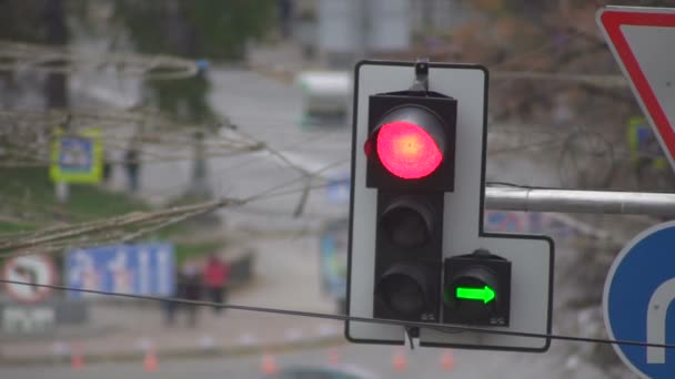 Semáforo rojo se enciende en un fondo de coches en movimiento en una carretera de la ciudad — Vídeo de stock