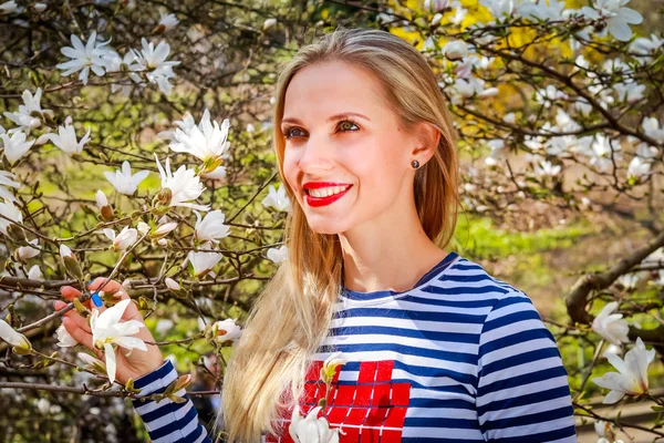 Young beautiful blonde woman in blooming garden. Magnolias blossom. — Stock Photo, Image