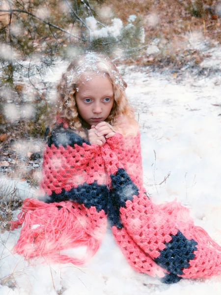 Kleines trauriges Mädchen gefroren im Winterwald Stockbild