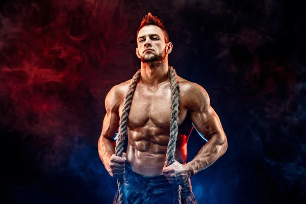 Сильний атлетичний чоловік з голим тілом у військових штанях і мотузкою на шиї чорний — стокове фото