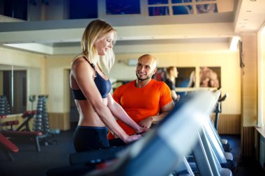 Sarışın kadın soran eğitmen sağlık kulübü, makineler hakkında