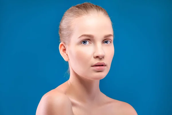 Portret van mooie vrouwelijke model op blauwe achtergrond — Stockfoto