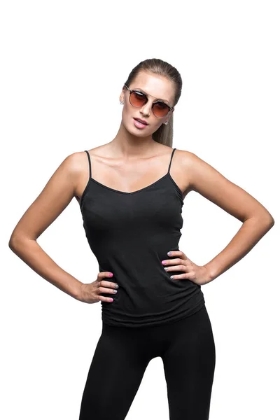 Portrait de la jeune blonde sportive sexuelle portant des lunettes de soleil. Isolé sur White. Chemise noire, leggins serrés . — Photo