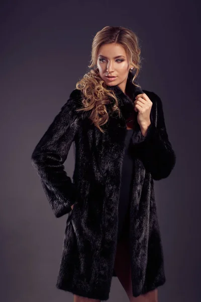 Retrato de una hermosa mujer rubia en abrigo de piel negro —  Fotos de Stock