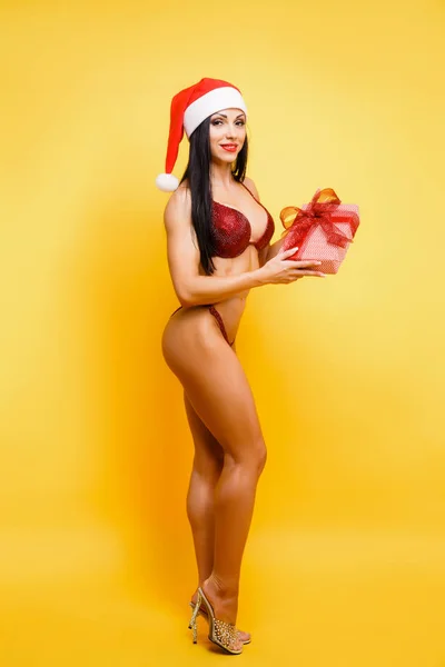 Kırmızı bikini ve santa şapka içinde güzel fitness modeli — Stok fotoğraf