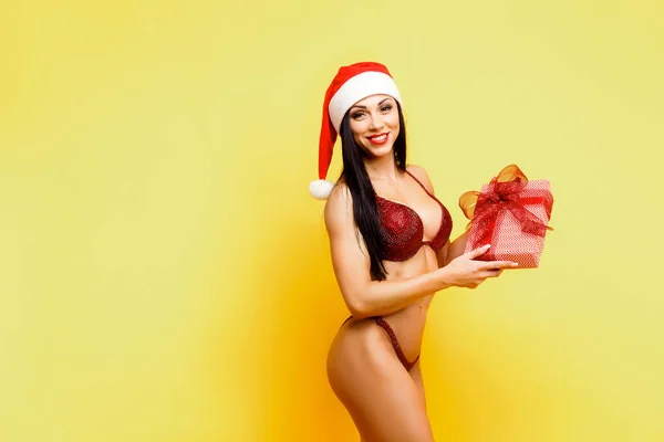 Beautiful fitness model in a red bikini and santa hat Stock Photo