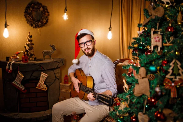 Man playing guitar in Christmas Eve — Stock Photo, Image