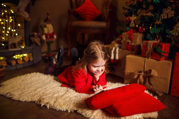 Ξαπλωμένος στο χαλί με το μικρό κορίτσι παρουσιάζει γύρω από τη χρήση tablet σε κόκκινο μαξιλάρι. — Φωτογραφία Αρχείου