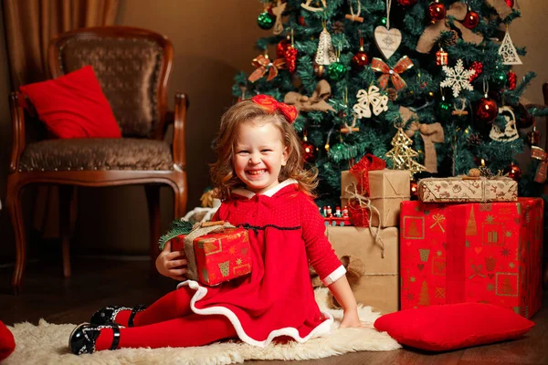 Smiling little girl among Christmas presents — Stock Photo, Image