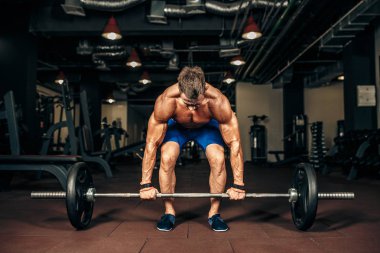 Spor salonunda Deadlift egzersiz yaparak gömleksiz delikanlı. motivasyon.