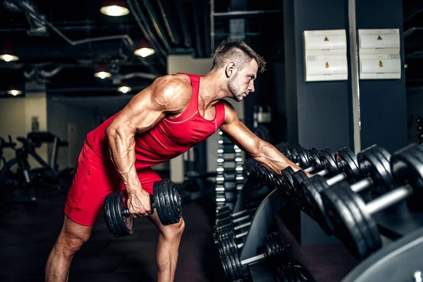 Spor salonunda ağır siyah halter kaldırma kararlı vücut geliştirmeci. — Stok fotoğraf