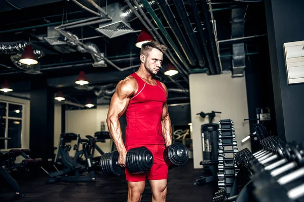 Beau musclé homme travaille et pose dans une salle de gym — Photo