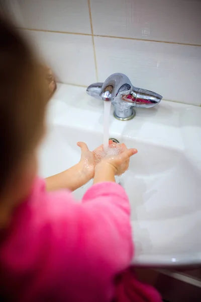 Oldalnézetből a lófarok rózsaszín fürdőköpeny mosás meg a kezét az aranyos kis lány. Copyspace — Stock Fotó