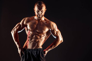 Mükemmel karın kasları, omuzları, pazıları olan güçlü bir vücut geliştirici.