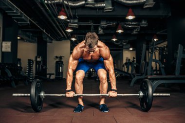 Spor salonunda Deadlift egzersiz yaparak gömleksiz delikanlı. motivasyon.