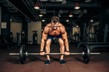 Spor salonunda Deadlift egzersiz yaparak gömleksiz delikanlı. motivasyon.
