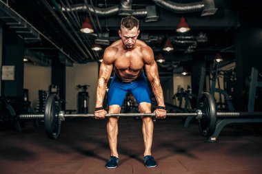 Spor salonunda Deadlift egzersiz yaparak gömleksiz delikanlı. motivasyon.