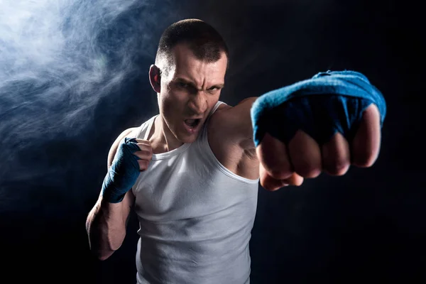 Muscular kickbox o muay thai luchador puñetazos en el humo . —  Fotos de Stock