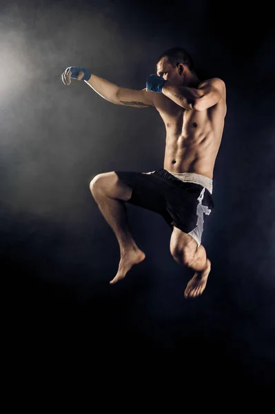 Μυϊκή kickbox ή muay Ταϊλανδός μαχητής punching στο άλμα. Καπνός. — Φωτογραφία Αρχείου