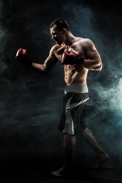 Kickbox musculaire ou muay thai boxeur poinçonnage en fumée . — Photo