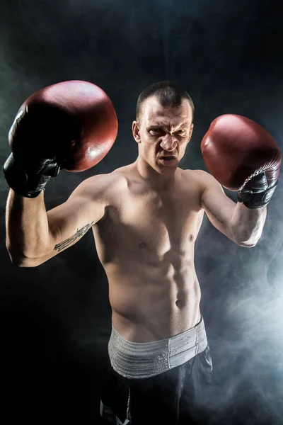 Muscular kickbox ou muay thai lutador perfurando na fumaça . — Fotografia de Stock