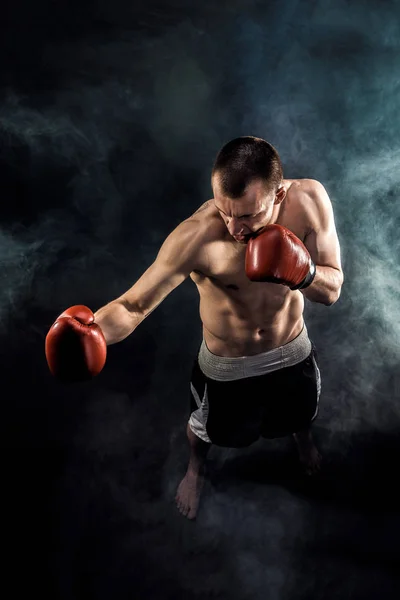 Muscular kickbox ou muay thai lutador perfurando na fumaça . — Fotografia de Stock