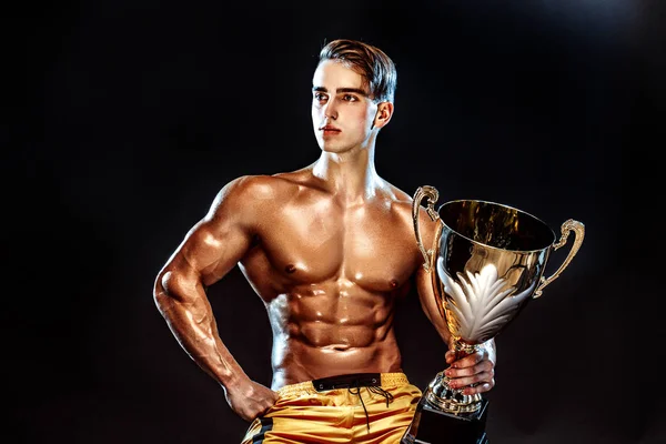 Champion de bodybuilding avec tasse . — Photo