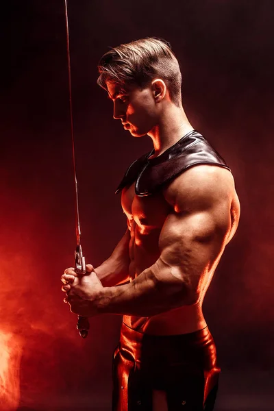 Porträt eines muskulösen, konzentrierten Mannes mit Schwert. — Stockfoto