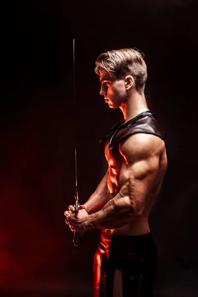Portret seksowny mięśni człowieka skoncentrowanego, trzymając miecz. — Zdjęcie stockowe