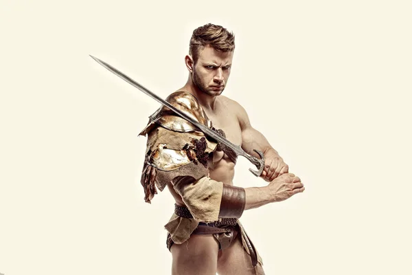 Muskulös krigare med svärd mot vit bakgrund — Stockfoto