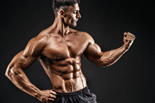 Bodybuilder posiert. Schöner sportlicher Typ mit männlicher Power. Fitness muskulöser Mann — Stockfoto